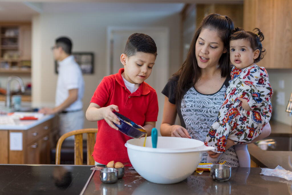 Young boy cooking with his mother